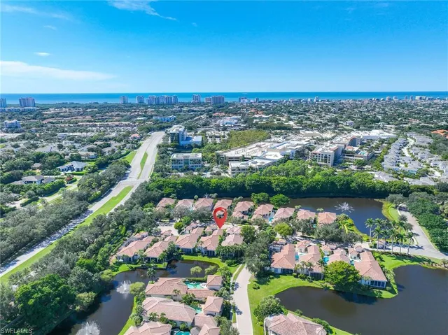an aerial view of a city with lots of residential buildings ocean and mountain view in back