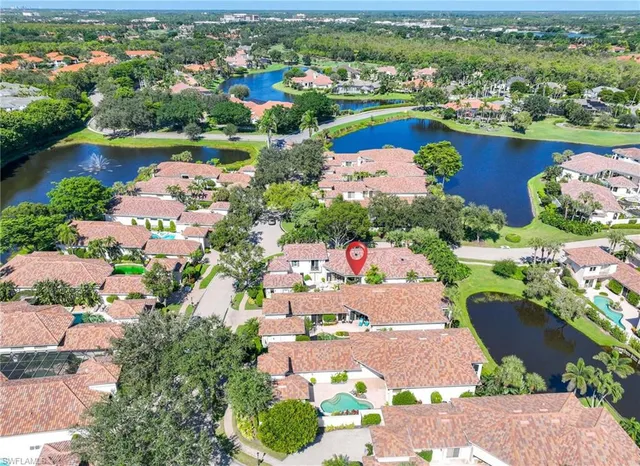 an aerial view of a city with lots of residential buildings ocean and mountain view in back