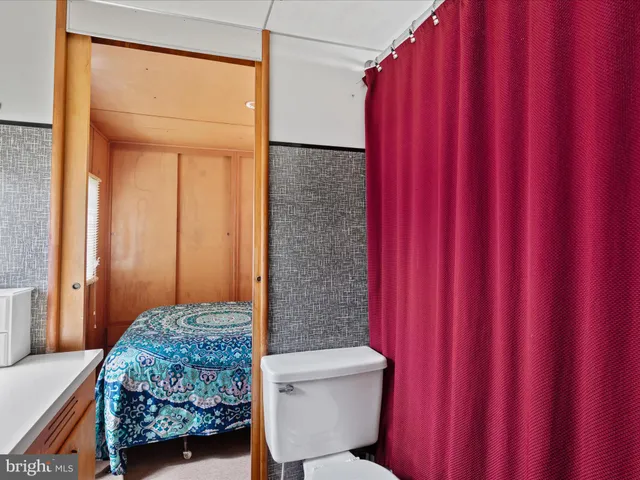 a bathroom with a toilet and a shower curtain