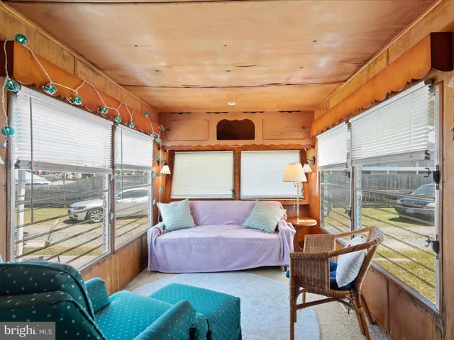 a bedroom with a bed and large windows