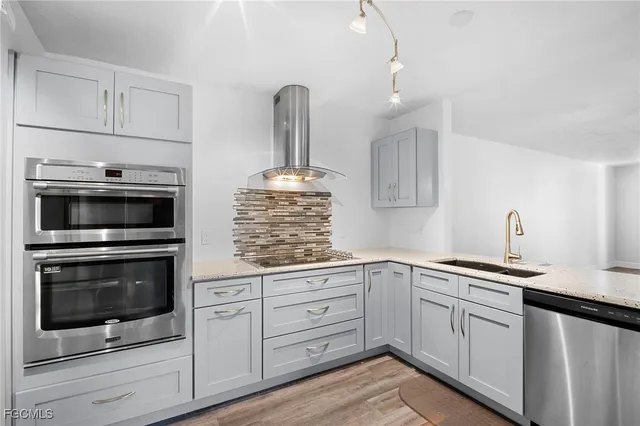 a kitchen with stainless steel appliances granite countertop a stove and white cabinets