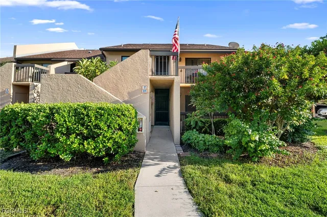 a front view of a house with a yard and potted plants