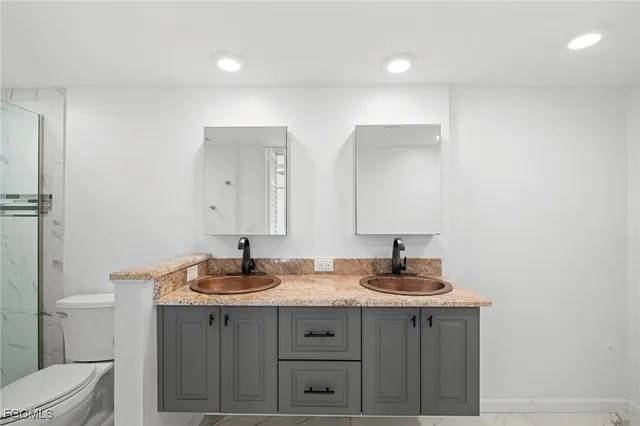 a bathroom with a sink a toilet and a mirror