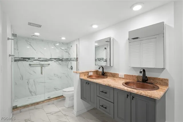 a bathroom with a granite countertop sink mirror and toilet