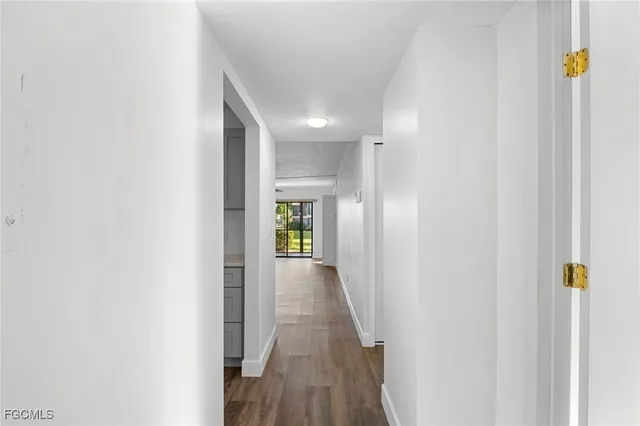 a view of a hallway with wooden floor