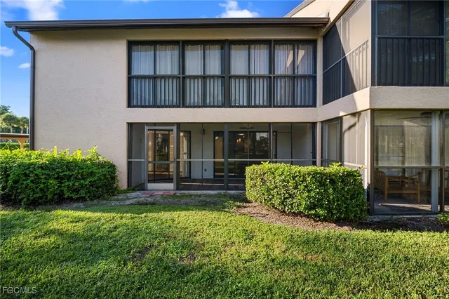 a view of a house with brick walls and a yard with plants