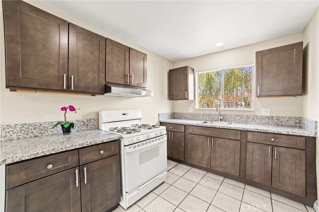 3717 Roosevelt Street Riverside, CA 92503 - Photo 17 of 23 a kitchen with granite countertop cabinets sink and a stove