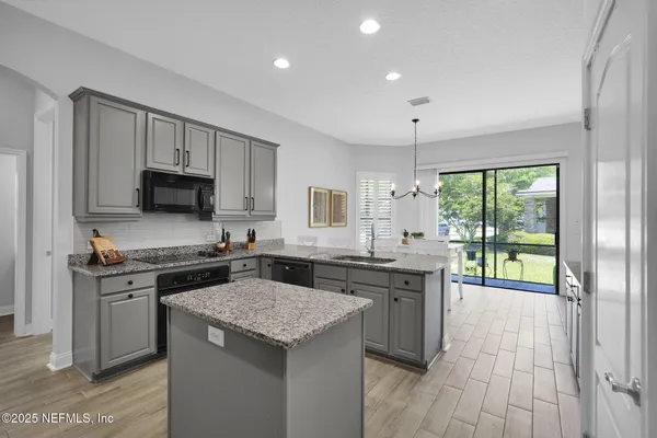 a kitchen with granite countertop a stove top oven sink and cabinets