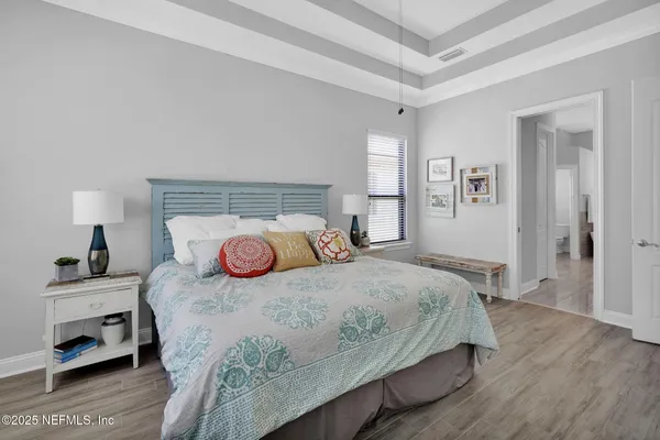 a bedroom with a bed and wooden floor