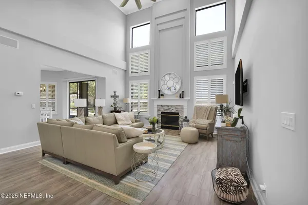 a living room with furniture a fireplace and a floor to ceiling window