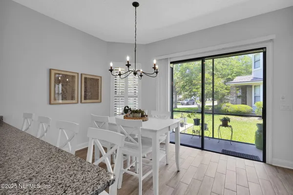 a dining room with furniture a chandelier and wooden floor