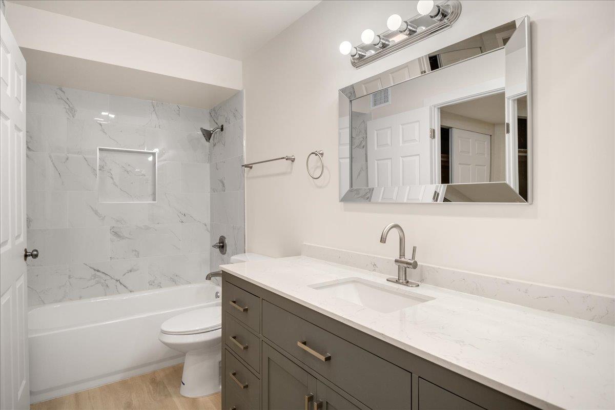 127 Rancho Drive San Jose, CA 95111 - Photo 13 of 25 a bathroom with a sink a toilet a large mirror a bathtub and shower