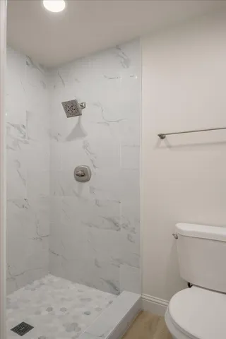 a bathroom with a shower a toilet and sink