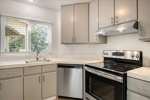 a kitchen with a sink stove and cabinets