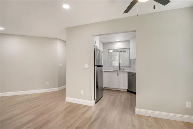 a view of a kitchen with a sink and a refrigerator