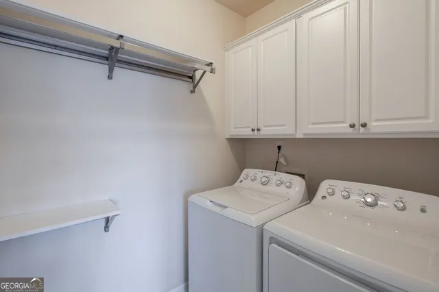 a bedroom with a large bed chandelier and a large window