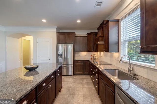 a kitchen with stainless steel appliances granite countertop a sink stove and refrigerator