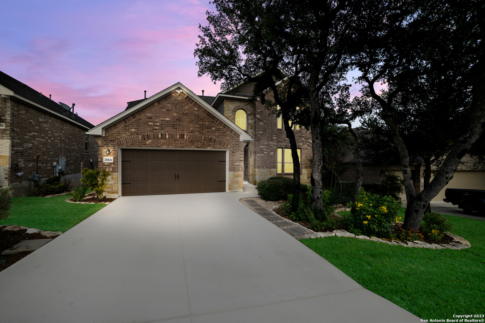 a front view of a house with a garden and yard