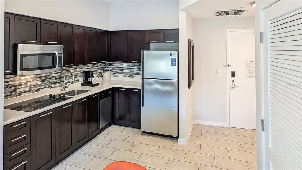 225 Celebration Place, Unit 212 Celebration, FL 34747 - Photo 16 of 35 a kitchen with stainless steel appliances a refrigerator a stove a microwave and sink
