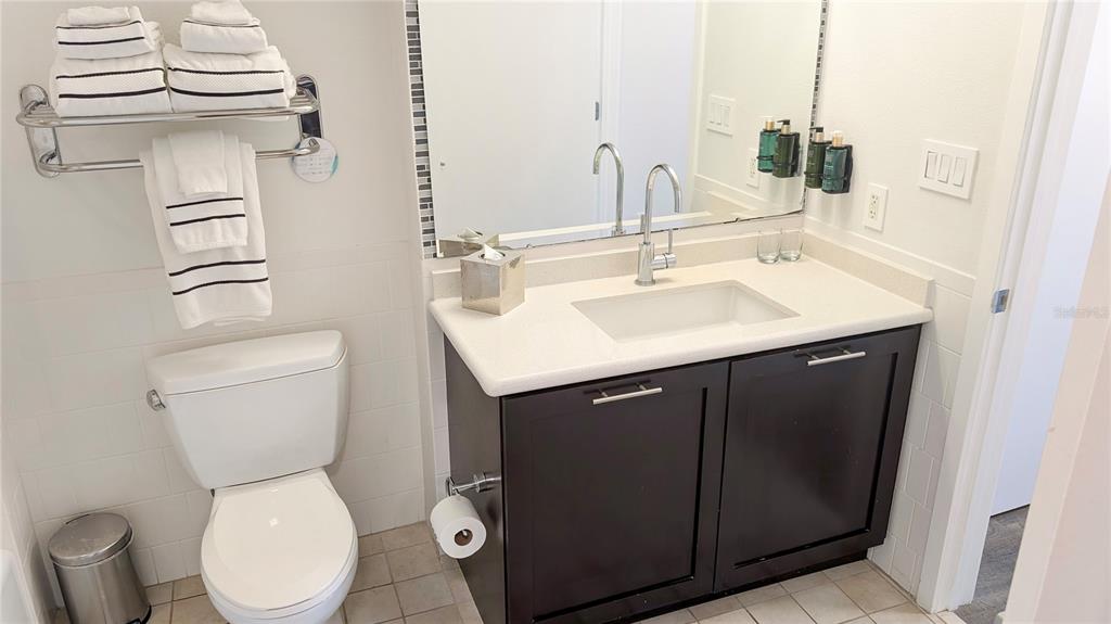225 Celebration Place, Unit 212 Celebration, FL 34747 - Photo 23 of 35 a bathroom with a toilet sink and mirror