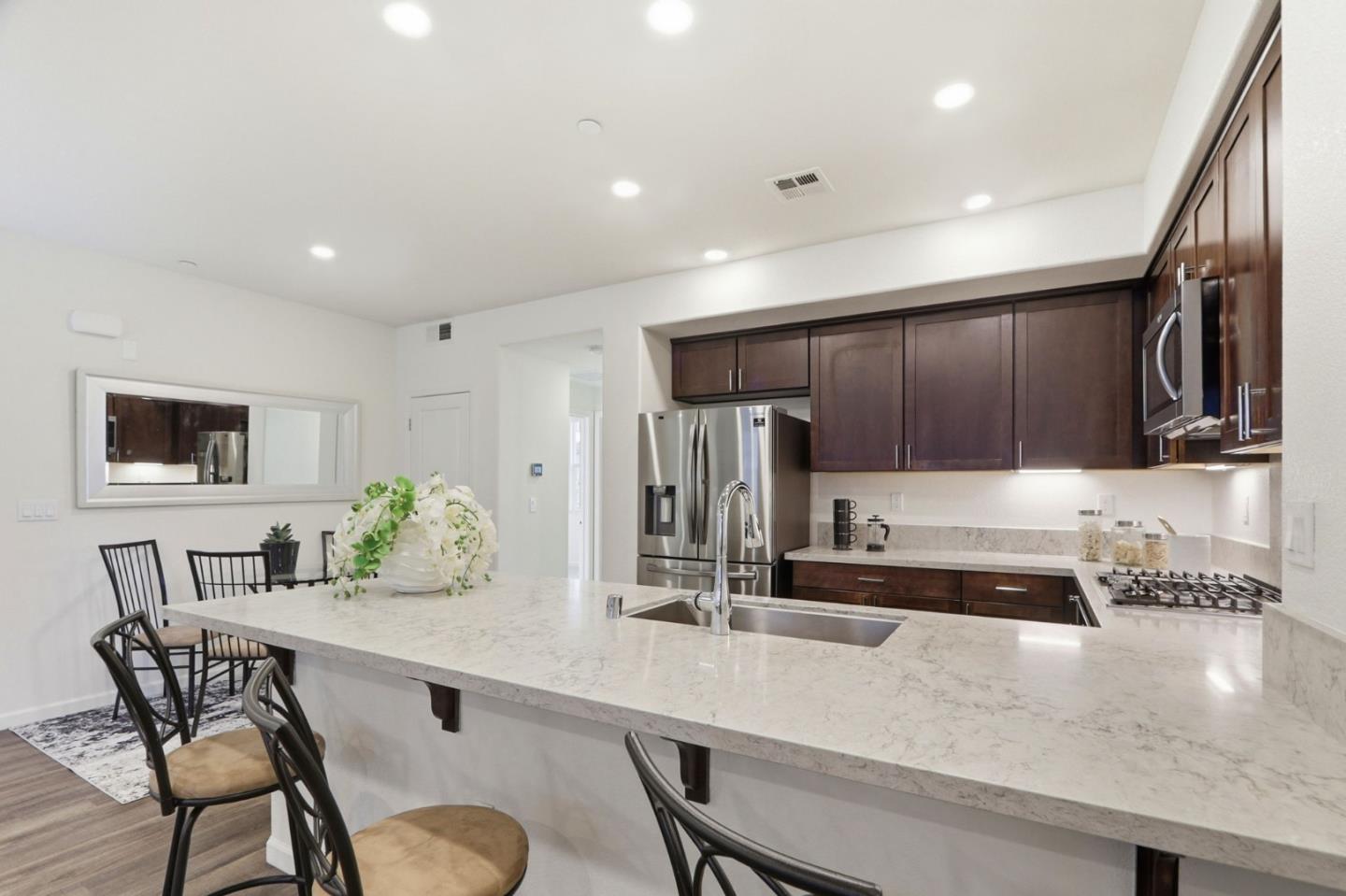 637 Clover Circle Milpitas, CA 95035 - Photo 10 of 39 a kitchen with granite countertop a table chairs stove microwave and cabinets