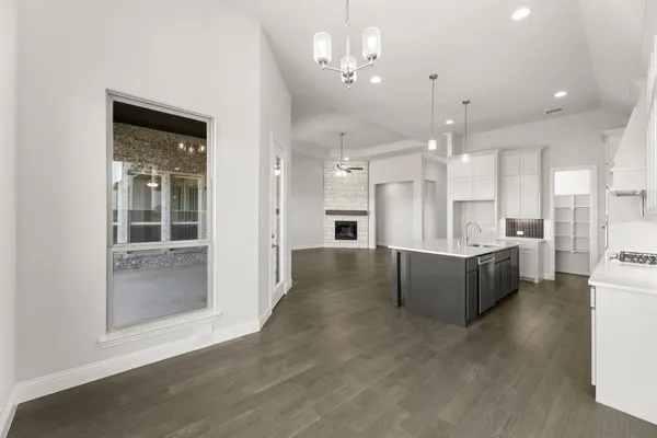 a view of a kitchen with a refrigerator a sink dishwasher and a fireplace