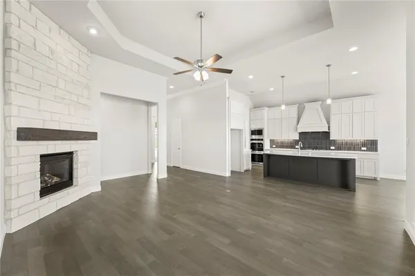 a view of kitchen with granite countertop stove top oven and cabinets