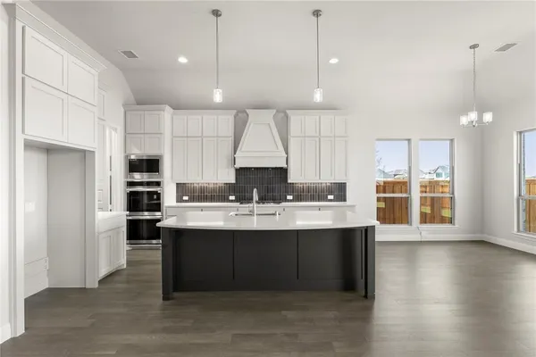 a large kitchen with kitchen island a sink stainless steel appliances and cabinets