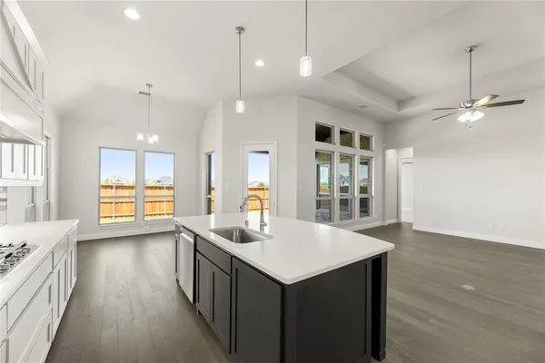a kitchen with counter top space and wooden floor