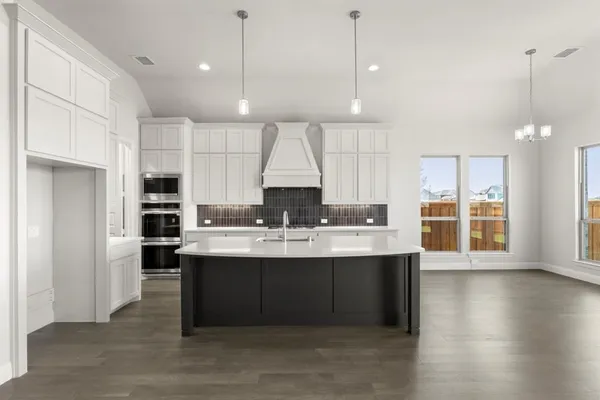 a large kitchen with kitchen island a sink stainless steel appliances and cabinets