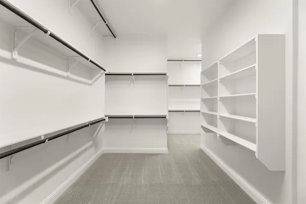 a view of walk in closet with empty racks