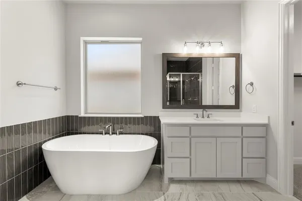 a bathroom with a tub sink and mirror