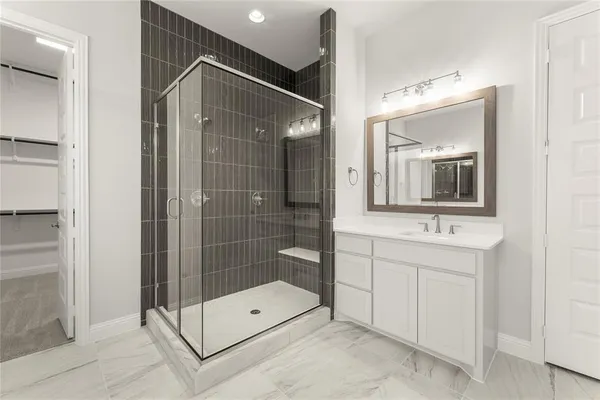 a bathroom with a shower sink and mirror