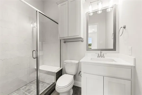 a bathroom with a toilet sink vanity and mirror