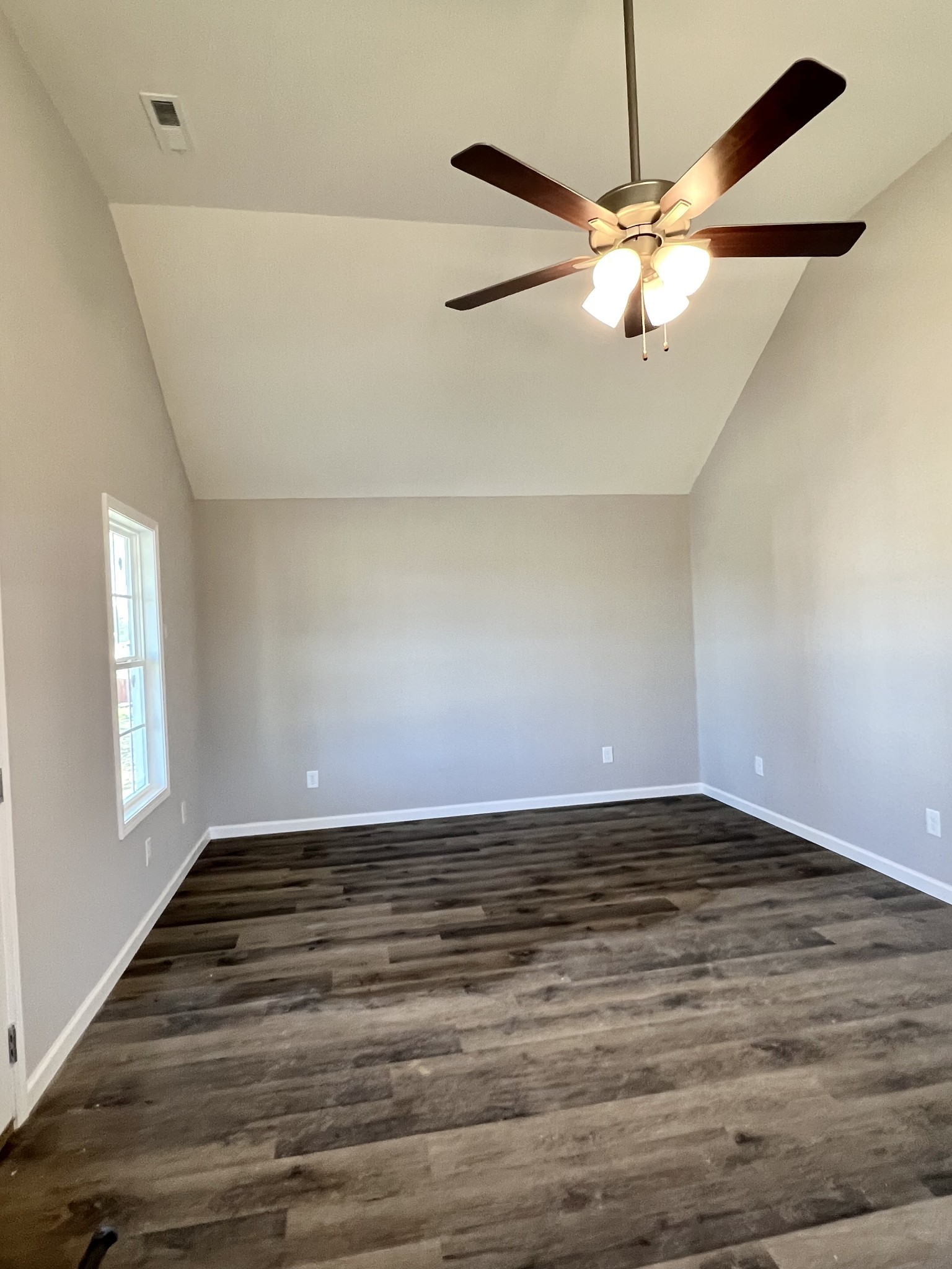 120 Liberty Street Portland, TN 37148 - Photo 4 of 12 an empty room with wooden floor fan and windows
