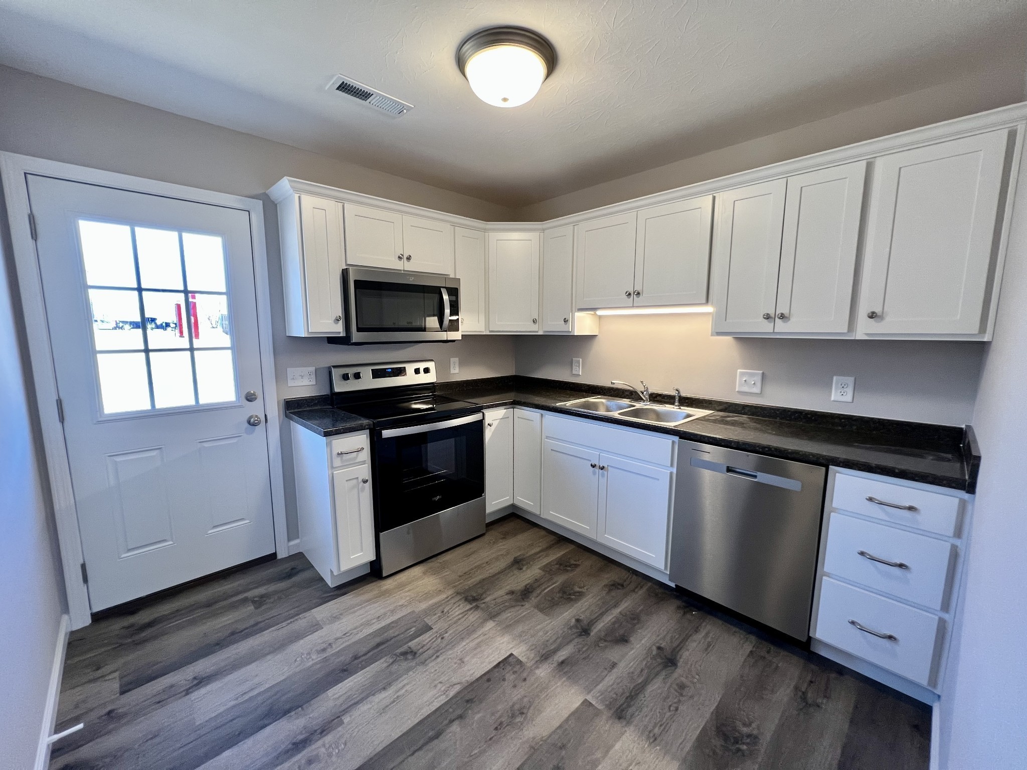 120 Liberty Street Portland, TN 37148 - Photo 5 of 12 a kitchen with granite countertop a stove top oven sink and cabinets
