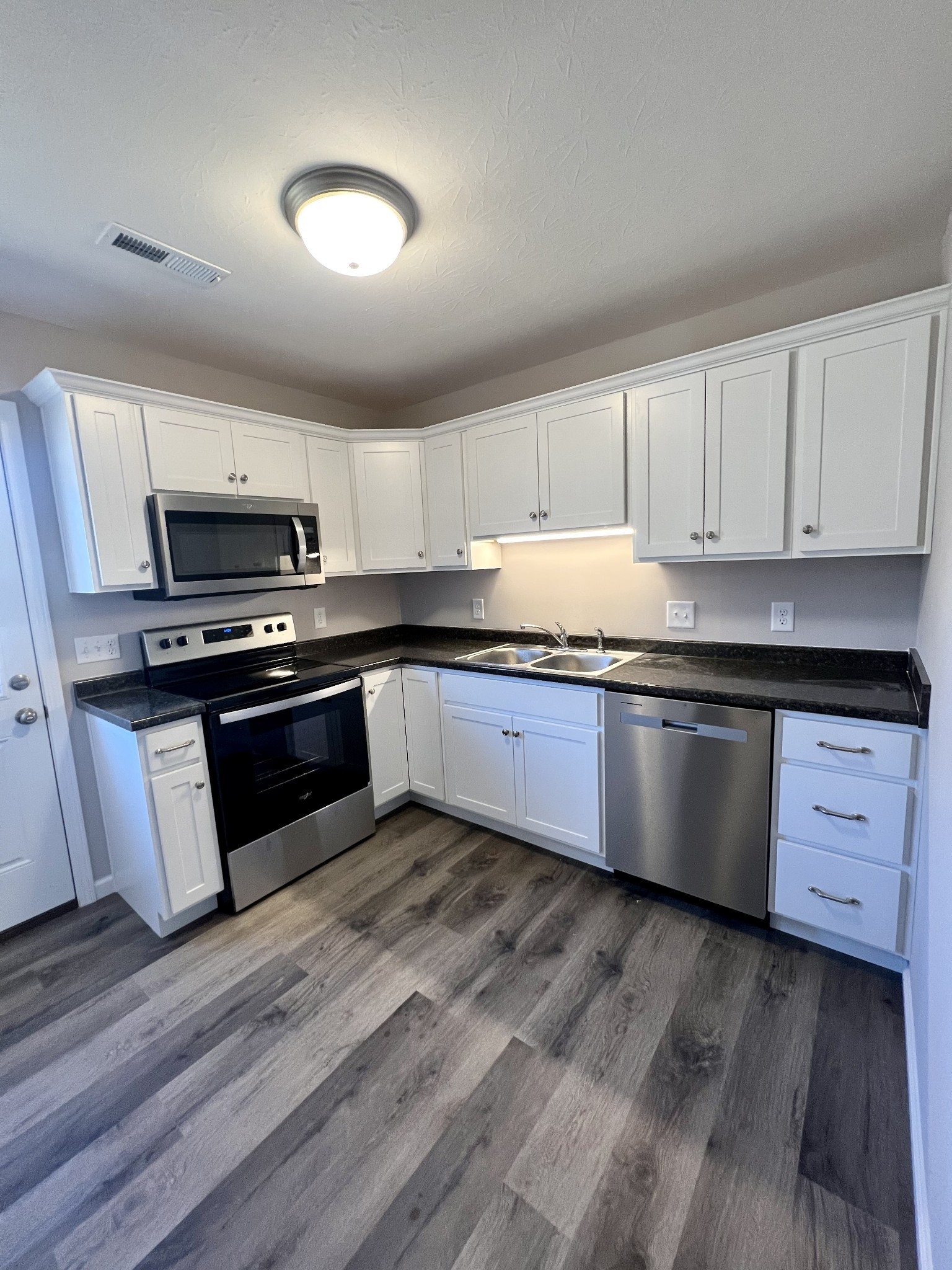 120 Liberty Street Portland, TN 37148 - Photo 6 of 12 a kitchen with granite countertop wooden cabinets and stainless steel appliances