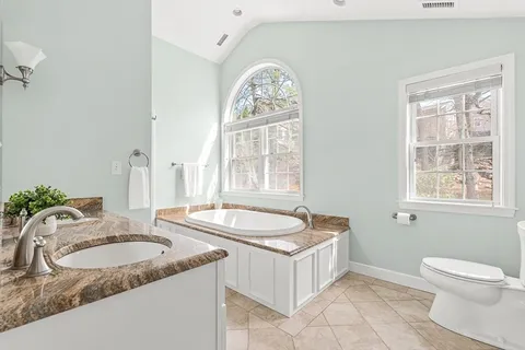 a bathroom with a tub sink and mirror
