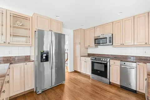 a kitchen with cabinets stainless steel appliances a sink and a window