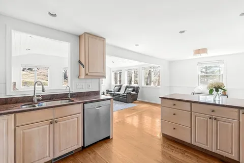 a kitchen with kitchen island granite countertop a stove a sink a refrigerator dining table and chairs