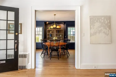 a view of a a dining room with furniture window and wooden floor