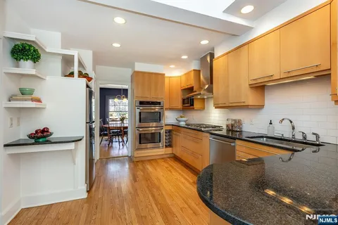 a kitchen with stainless steel appliances granite countertop a sink a stove top oven a counter space and cabinets