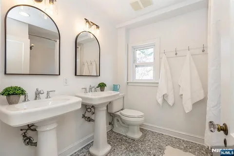 a bathroom with a sink and mirror with toilet