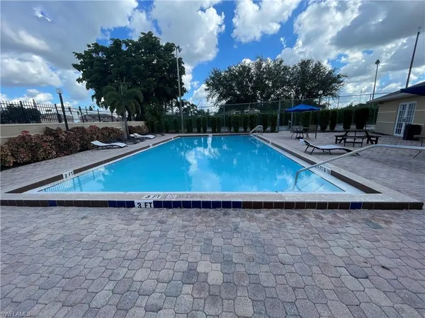 a view of a backyard with kitchen island a stove a barbeque oven and a fireplace