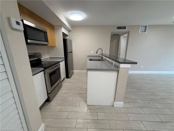 a kitchen with a stove microwave and sink