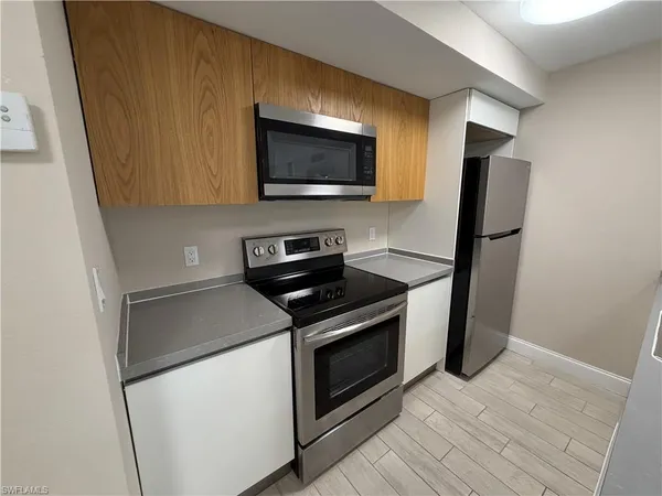 a view of a sink and dishwasher with wooden floor