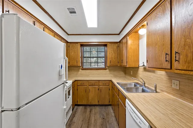 a kitchen with granite countertop a sink a counter space and stainless steel appliances