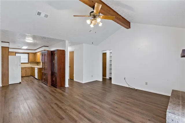 a view of an empty room with a kitchen