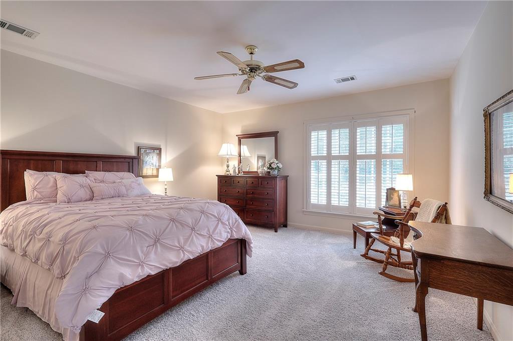 600 River Cove Road Social Circle, GA 30025 - Photo 31 of 45 a spacious bedroom with a bed a table and a large window