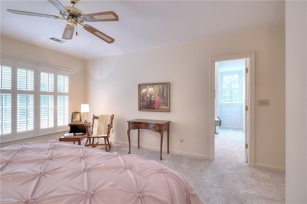 600 River Cove Road Social Circle, GA 30025 - Photo 32 of 45 a bedroom with a bed and a chandelier